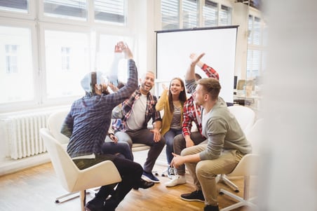 Excited creative business people giving high-five in meeting room at creative office-2